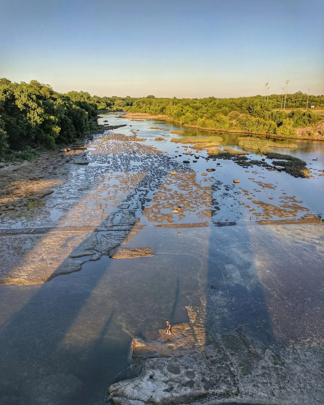 Little kid about to piss his dad off by jumping in the river.