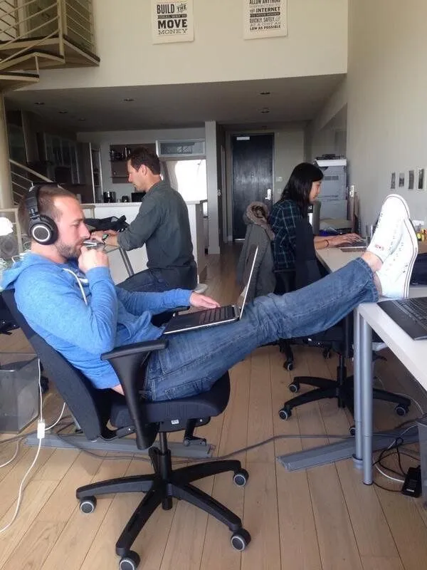 Engineers heads-down at a startup office, laptops and headphones